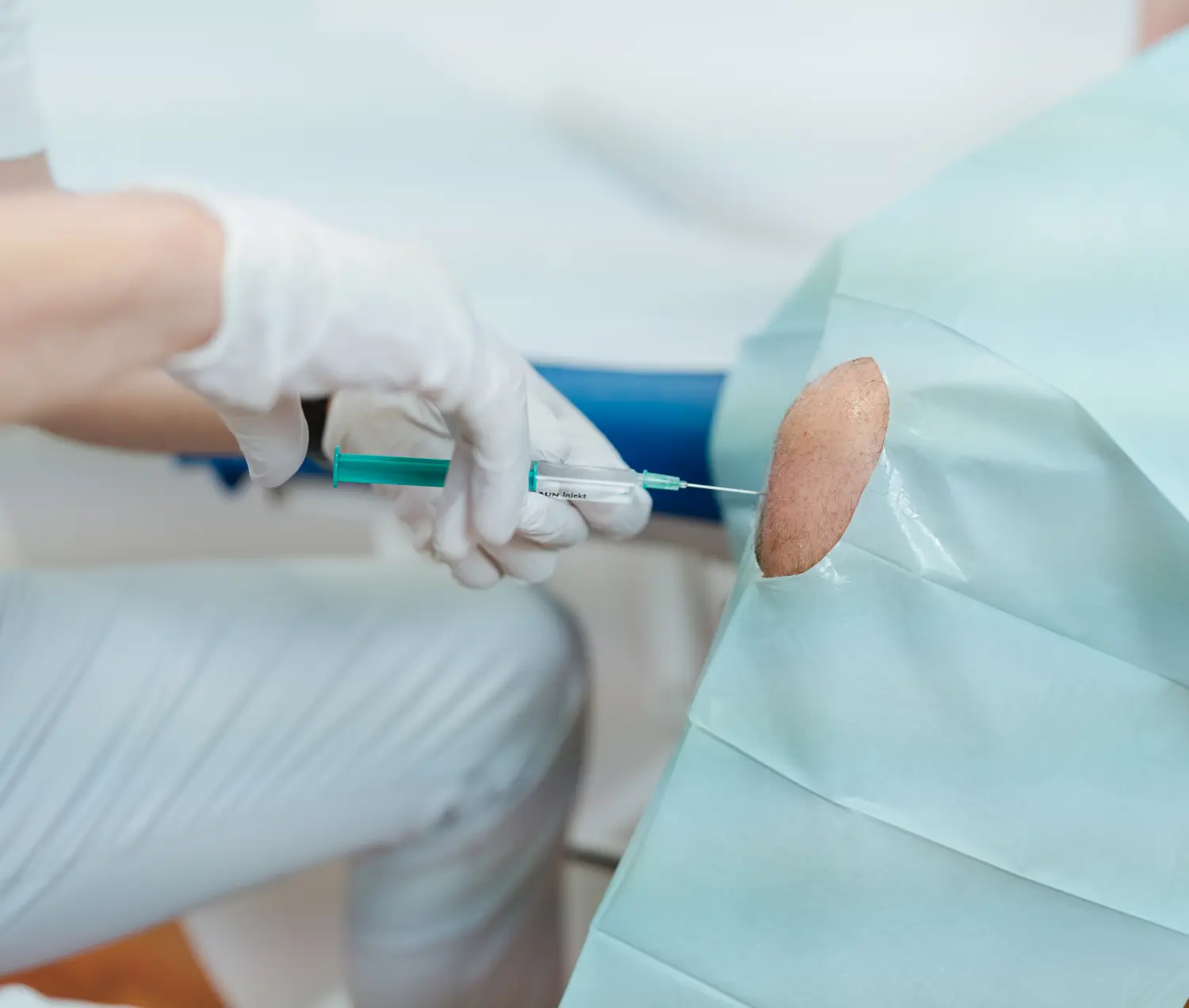 Metush Qorrolli gibt einem Patienten eine Injektion von Schmerzpraxis Qorrolli 